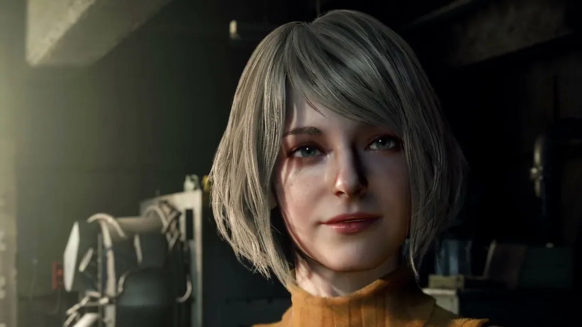 Ashley Graham souriante en pull orange, devant un projecteur, dans Resident Evil 4 (2023)