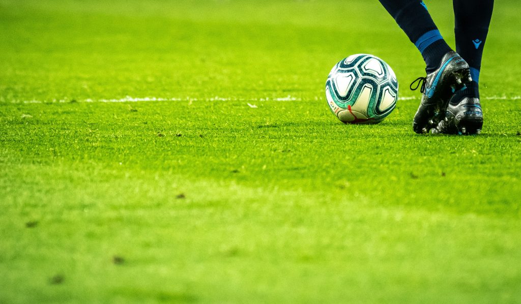 homme jouant au football sur le terrain